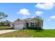 Charming single-story home with a manicured lawn, attached garage, and neutral-tone siding under a sunny sky at 2135 E Old Mill Dr, Deltona, FL 32725