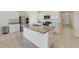 Modern kitchen featuring stainless steel appliances, granite countertops, a kitchen island, and neutral tile flooring at 2135 E Old Mill Dr, Deltona, FL 32725