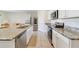 Well-lit kitchen with stainless steel appliances, granite countertops, white cabinets, and modern tile flooring at 2135 E Old Mill Dr, Deltona, FL 32725