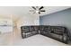 Open living room with tile floors, a large sectional sofa, ceiling fan, and view into the kitchen at 2135 E Old Mill Dr, Deltona, FL 32725