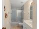 Bathroom featuring tile floors, a combined tub and shower with glass doors, and updated sink at 216 Bermuda Petrel Ct, Daytona Beach, FL 32119