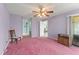 Comfortable bedroom with pink carpeting, light purple walls, and a sliding glass door at 216 Bermuda Petrel Ct, Daytona Beach, FL 32119