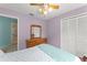 Bright bedroom featuring a ceiling fan, closet, and wooden dresser with beautiful light-purple colored walls at 216 Bermuda Petrel Ct, Daytona Beach, FL 32119