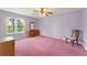 Bedroom featuring pink carpeting, a large window, and classic wooden furniture at 216 Bermuda Petrel Ct, Daytona Beach, FL 32119
