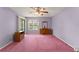 Bright bedroom with pink carpet, a large window, and a sliding glass door at 216 Bermuda Petrel Ct, Daytona Beach, FL 32119