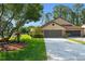 Charming home featuring a well-maintained lawn, mature trees, and an attached two-car garage at 216 Bermuda Petrel Ct, Daytona Beach, FL 32119
