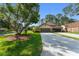 Charming single-story home with a well-manicured lawn, mature tree, and spacious driveway at 216 Bermuda Petrel Ct, Daytona Beach, FL 32119