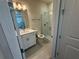 Bright bathroom with vanity, toilet, shower, and gray tile flooring at 2322 Daisy Tree Rd, St Cloud, FL 34771