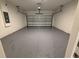 Spacious garage featuring epoxy flooring and a modern automatic door at 2322 Daisy Tree Rd, St Cloud, FL 34771