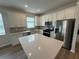 Bright kitchen with modern appliances, a center island, quartz countertops and a stylish backsplash at 2322 Daisy Tree Rd, St Cloud, FL 34771
