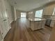 Living room and kitchen area boasts wood floors, light walls and plenty of natural light at 2322 Daisy Tree Rd, St Cloud, FL 34771