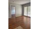 Open floor plan living room with wood floors and sliding glass door to the balcony at 238 Afton Sq # 204, Altamonte Springs, FL 32714