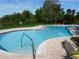 Well-maintained community pool with step access, surrounded by brick paving and lush landscaping at 238 Afton Sq # 204, Altamonte Springs, FL 32714