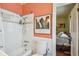 Clean bathroom with a white subway tile shower-tub combo, peach walls, and access to an adjacent bedroom at 2505 Amherst Ave, Orlando, FL 32804