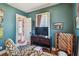 Comfortable living room featuring teal walls, hardwood floors, a decorative blanket rack, and natural light at 2505 Amherst Ave, Orlando, FL 32804