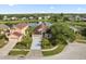 Aerial view of a single-Gathering home with an attached garage next to a beautiful lake and lush landscaping at 2506 Aster Cove Ln, Kissimmee, FL 34758