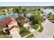 Aerial view of a home with a lake view surrounded by mature trees and lush landscaping at 2506 Aster Cove Ln, Kissimmee, FL 34758