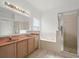 Bathroom featuring a double vanity, soaking tub, and separate shower at 2506 Aster Cove Ln, Kissimmee, FL 34758