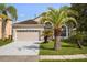 Charming single-Gathering home with a two-car garage, manicured lawn, and mature palm trees at 2506 Aster Cove Ln, Kissimmee, FL 34758