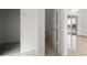 Hallway leading to a closet, bathroom, and sliding glass doors to an enclosed patio at 2506 Aster Cove Ln, Kissimmee, FL 34758