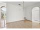 Open-concept living space featuring tile floors, neutral walls, an arched doorway, and an ornate light fixture at 2506 Aster Cove Ln, Kissimmee, FL 34758