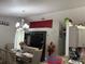 Inviting dining area and living room area featuring a large entertainment center, a modern chandelier and bright colors at 2514 Dovetail Dr, Ocoee, FL 34761