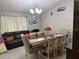 An open-concept dining room and living room area, featuring a large dining table and a leather couch for entertainment at 2514 Dovetail Dr, Ocoee, FL 34761
