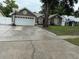 Charming single-story home featuring a two-car garage and driveway, a basketball hoop, and easy lawn maintenance at 2514 Dovetail Dr, Ocoee, FL 34761