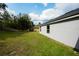 Large, green backyard showcasing ample space and a gray exterior home wall at 3422 Heath Dr, Deltona, FL 32725