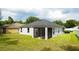 Home exterior showcasing a screened-in lanai and lush backyard perfect for outdoor living at 3422 Heath Dr, Deltona, FL 32725