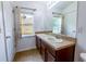 Bathroom features dual sinks, wood cabinets, large mirror and window for natural light and ventilation at 3422 Heath Dr, Deltona, FL 32725