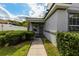 Charming home entrance with gray door, lush landscaping, and a well-maintained walkway at 3422 Heath Dr, Deltona, FL 32725