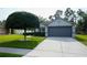 Charming home featuring a well-manicured lawn, two-car garage, and stylish gray exterior at 3422 Heath Dr, Deltona, FL 32725