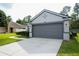 Home featuring a spacious two-car garage, well-manicured lawn, and a paved driveway at 3422 Heath Dr, Deltona, FL 32725