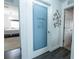 Hallway view of laundry room with decorative door, grey wood floors, and bedroom entrance at 3422 Heath Dr, Deltona, FL 32725
