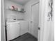 Laundry room featuring side-by-side washer and dryer, storage shelf, and modern gray flooring at 3422 Heath Dr, Deltona, FL 32725
