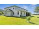 Expansive backyard featuring lush green grass, with a screened patio and views of a serene field at 4394 Devon Ct, Kissimmee, FL 34746