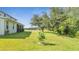 Expansive backyard featuring lush green grass, mature trees and a view of the lake at 4394 Devon Ct, Kissimmee, FL 34746