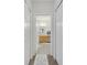 Hallway view into a well-lit bathroom featuring a wood vanity, tile floor, and framed mirror at 4394 Devon Ct, Kissimmee, FL 34746