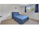 Comfortable bedroom features a large window with curtains and a bed with blue bedding at 4394 Devon Ct, Kissimmee, FL 34746