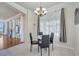 Cozy dining area features a round glass table, chandelier, and natural light from the large window at 4394 Devon Ct, Kissimmee, FL 34746