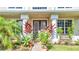 Inviting front entrance featuring a stylish door, decorative plants, and manicured landscaping at 4394 Devon Ct, Kissimmee, FL 34746