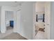 Bright hallway featuring closet, doorways into a bedroom and bathroom with tile flooring and neutral paint at 4394 Devon Ct, Kissimmee, FL 34746