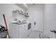 Clean laundry room features modern washer and dryer units, shelving and a white door at 4394 Devon Ct, Kissimmee, FL 34746