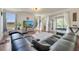 Bright living room featuring hardwood floors, large windows, and a comfortable sectional sofa at 4394 Devon Ct, Kissimmee, FL 34746
