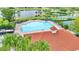 Community pool featuring a red-roofed clubhouse surrounded by palm trees and views of the nearby lake at 4394 Devon Ct, Kissimmee, FL 34746