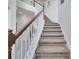 Carpeted staircase with white spindles and dark wood railing providing an elegant transition between floors at 4394 Devon Ct, Kissimmee, FL 34746