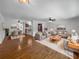 Open-concept living room with hardwood floors, ceiling fan, and views of the dining area and kitchen at 520 Sumner Ave, Orange City, FL 32763