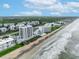 Breathtaking aerial perspective showcasing the beachfront condominium complex, highlighting its prime location on the sandy shores at 5207 S Atlantic Ave # 225, New Smyrna Beach, FL 32169