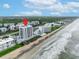 Breathtaking aerial perspective showcasing the beachfront condominium complex, highlighting its prime location on the sandy shores at 5207 S Atlantic Ave # 225, New Smyrna Beach, FL 32169